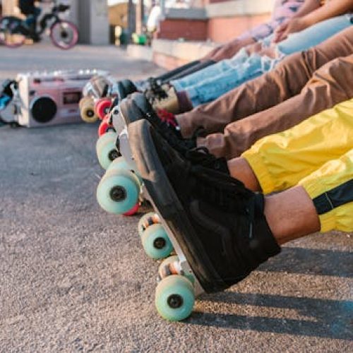 A group of friends relaxing in line with vibrant roller skates at an outdoor skatepark.